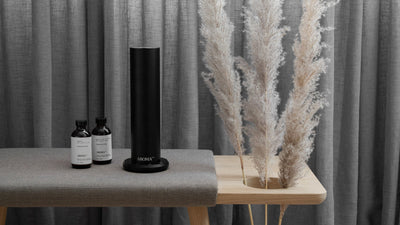 AroMini BT electric oil diffuser on table with Aroma Oil