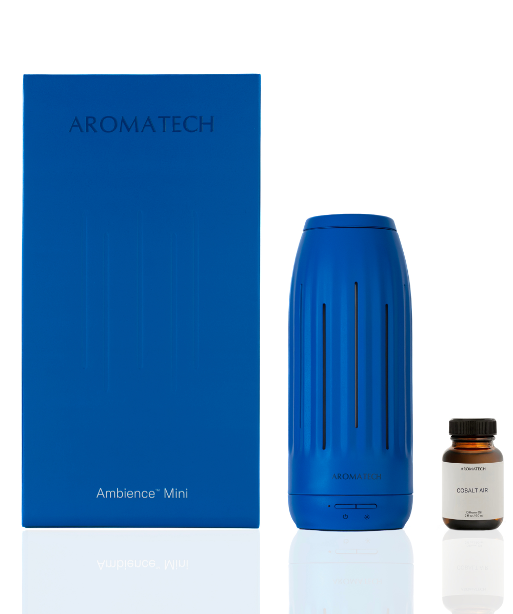 A blue Aromatech Ambience Mini diffuser shown next to its blue retail box and a small amber bottle labeled 'Cobalt Air' on a white background.
