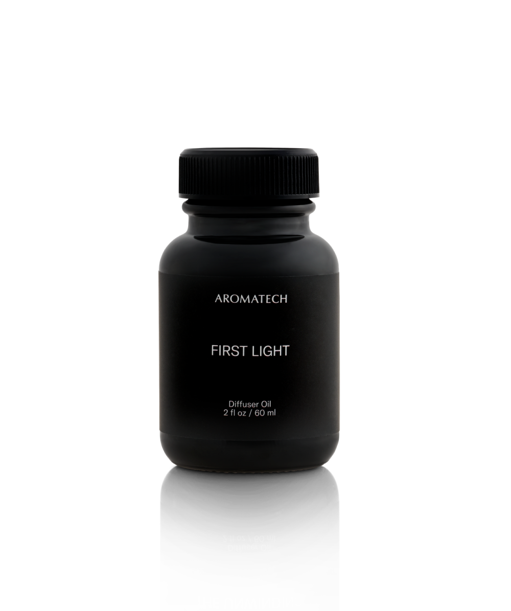 Black bottle of Aromatech First Light diffuser oil on a white background